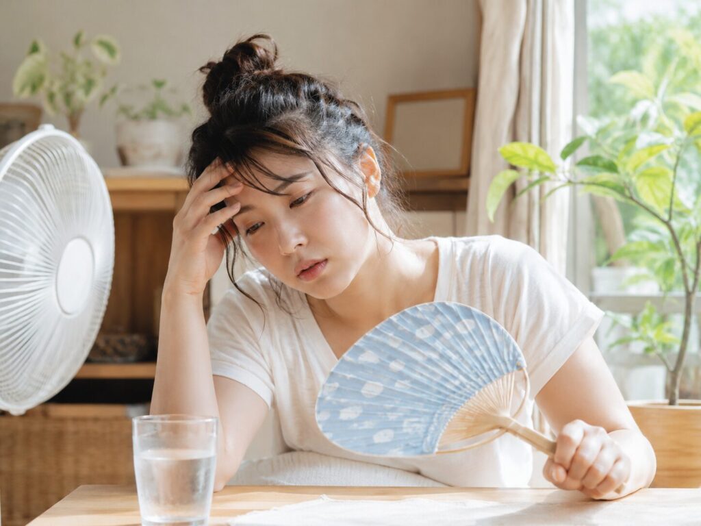 夏バテでだるそうにしている女性の画像
