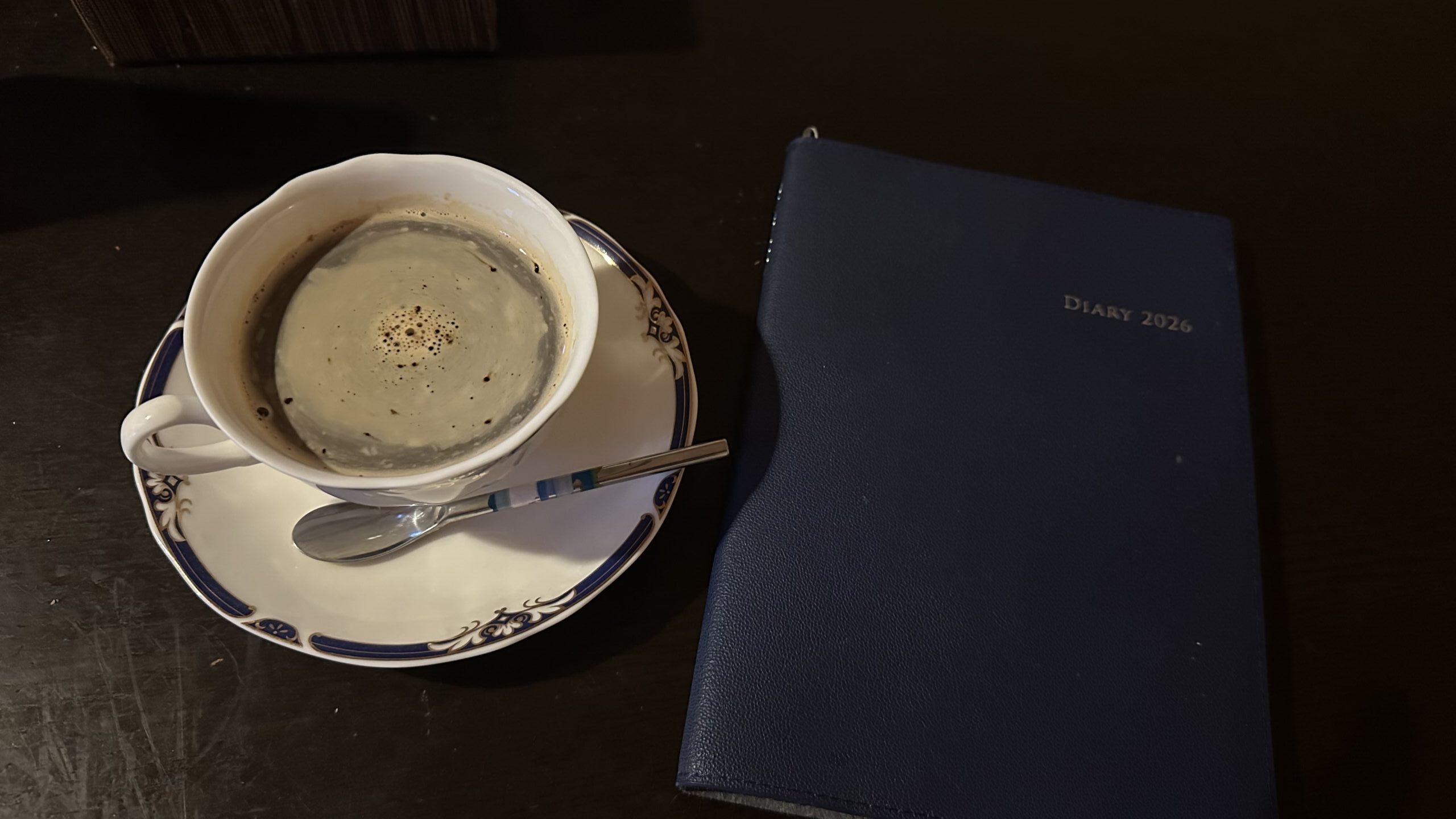 温かいコーヒーとノートを並べた写真