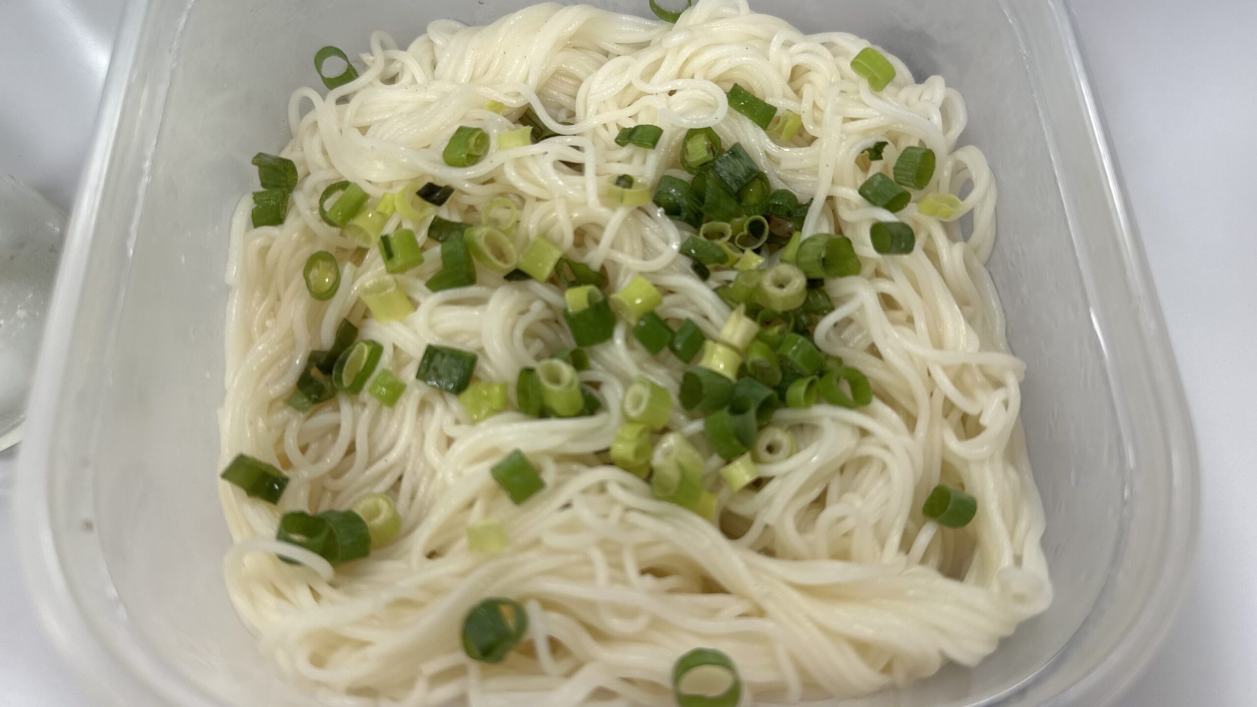 保存容器に入れたそうめんと刻みねぎの昼食